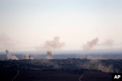 Smoke and explosions from the fighting between forces loyal to Syrian President Bashar Assad and rebels rise in the village of Jubata al-Khashab as seen from the Israeli-controlled Golan Heights, Sept. 11, 2016.