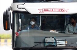 Seorang supir bus mengenakan masker wajah di terminal bus Pulo Gebang di tengah wabah virus corona (Covid-19) di Jakarta, 12 April 2020. (Foto: Reuters)