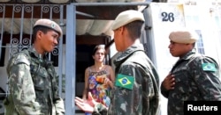 FILE - Brazilian soldiers conduct an inspection for the Aedes aegypti mosquito as part of efforts to prevent the spread of the Zika virus, along a street in Sao Paulo, Brazil, Feb. 1, 2016.
