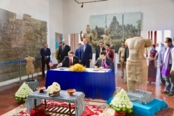 មន្ត្រី​តំណាង​ស្ថានទូត​សហរដ្ឋអាមេរិក​និង​មន្ត្រី​តំណាង​ក្រសួង​វប្បធម៌​និង​វិចិត្រ​សិល្បៈ​ចូលរួម​ក្នុង​ពិធី​ប្រគល់​រូបបដិមា​ខ្មែរ​ចំនួន​ពីរ ​ដែល​ស្ថានទូត​សហរដ្ឋអាមេរិក​ប្រគល់​ជូន​កម្ពុជា​វិញ ក្រោយ​ពី​រឹបអូស​បាន​កាល​ពី​ឆ្នាំ​២០០៥​និង​២០១៧​នៅ​សហរដ្ឋអាមេរិក ថ្ងៃ​ទី​៣ ខែមេសា ឆ្នាំ​២០២០។ (រូបថត​ផ្ដល់​ឲ្យ​ដោយ​ស្ថានទូត​អាមេរិក)