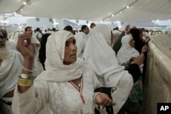 Indian women cast stones at a pillar symbolizing the stoning of Satan, in a ritual called Jamarat, the last rite of the annual Hajj, in Mina near the holy city of Mecca, Saudi Arabia, Sept. 12, 2016.