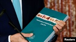 U.S. Secretary of State John Kerry holds a copy of the 2016 Trafficking in Persons (TIP) report for 2016.