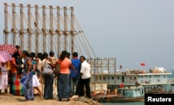 FILE - A group of Sri Lankan visitors at the new deep water shipping port watch a Chinese dredging ships work in Hambantota, March 24, 2010.
