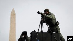 SWAT personnel keep watch beside the Washington Memorial in Washington, Jan. 19, 201.