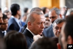 FILE - Turkey's President Recep Tayyip Erdogan talks to MPs of his ruling Justice and Development Party after speaking at the parliament in Ankara, Nov. 20, 2018.