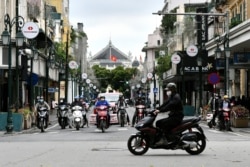 Pengendara motor di sebuah jalan di Hanoi setelah pemerintah Vietnam melonggarkan karantina wilayah untuk mencegah penyebaran virus corona, 23 April 2020.