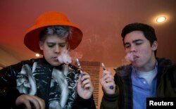 FILE - Customers puff on e-cigarettes at the Henley Vaporium in New York City December 18, 2013.