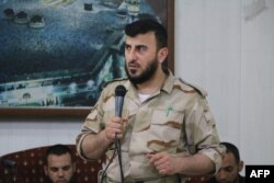 FILE - Zahran Alloush, head of the Army of Islam Syrian rebel group, speaks during the wedding of a fighter in the group in the rebel-held town of Douma, on the eastern edge of Damascus, Syria, July 21, 2015.