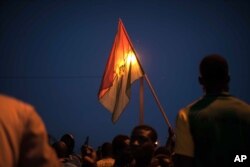 A protester holds a Burkina Faso national flag during a protest against a recent coup in Ouagadougou, Burkina Faso, Sept. 21, 2015.