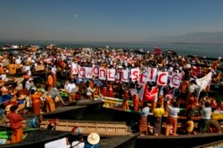 Komunitas etnis Entha memegang plakat saat berpartisipasi dalam aksi protes menentang kudeta militer di Danau Inle, Taunggyi, Myanmar, Kamis, 11 Februari 2021.
