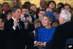 First Lady Nancy Reagan looks on as President Ronald Reagan is sworn in, January 21, 1985.