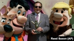 Joseph Barbera poses with famed Hanna-Barbera cartoon characters, from left, Scooby Doo, Fred Flintstone and Barney Rubble