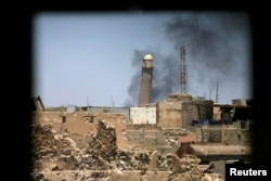 FILE - Al-Hadba minaret at the Grand Mosque is seen through a building window in the old city of Mosul, Iraq June 1, 2017.