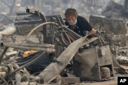 Kristine Pond searches the remains of her family's home destroyed by fires in Santa Rosa, Calif., Oct. 9, 2017.