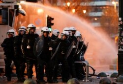 Policijske snage čuvaju stražu dok ljudi protestuju protiv mera korona virusa (COVID-19) u blizini Evropske komisije u Briselu, Belgija, 21. novembra 2021.