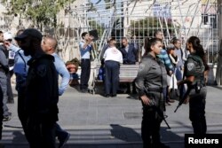 Israeli security personnel and medics stand at the area where a stabbing attack by two Palestinian women took place in central Jerusalem, Nov. 23, 2015.
