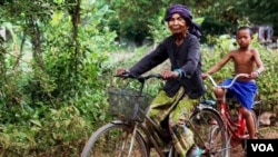 Im Chaem, a former Khmer Rouge cadre, is riding a bike along with her grandson in Along Veng, in Oddar Meanchey province in Cambodia, Sunday April 23, 2017. (Sun Narin/VOA Khmer)