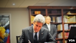 Secretary of State John Kerry signs the book of condolences for His Majesty King Bhumibol Adulyadej