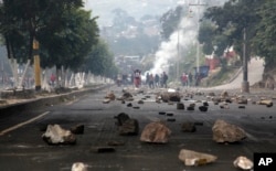 Rocks are scattered on a road, placed there by protesters, in Tegucigalpa, Honduras, Friday, Dec. 15, 2017.