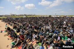 Palestinians attend Friday prayer during a tent city protest along the Israel border with Gaza, demanding the right to return to their homeland, in the southern Gaza Strip, March 30, 2018.