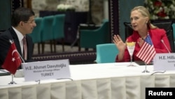 Foreign Affairs Minister Ahmet Davutoglu of Turkey listens to U.S. Secretary of State Hillary Clinton as they attend a "Friends of Syria" meeting in Istanbul June 6, 2012.