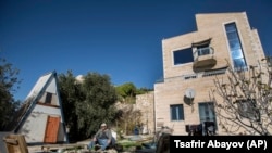 Moshe Gordon sits outside his guest house advertised on the Airbnb international home-sharing site in Nofei Prat settlement in the West Bank.