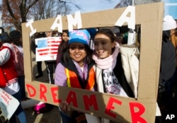 FILE - Demonstrators hold a sign during an immigration rally in support of the Deferred Action for Childhood Arrivals (DACA), on Capitol Hill in Washington, Dec. 6, 2017.
