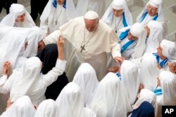 Pope Francis is greeted by a group of nuns during his weekly general audience in the Pope Paul VI hall at the Vatican, Wednesday, Aug. 22, 2018.