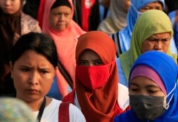 Pekerja pabrik sepatu berjalan pulang setelah pulang kerja, di kawasan industri Pasar Kemis di Tangerang 14 Agustus 2014. (Foto: Reuters/Beawiharta)