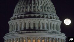 FILE - The moon rises behind the U.S. Capitol Dome in Washington, Dec. 30, 2012.