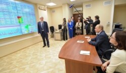 FILE - Russian President Vladimir Putin, second right, visits the center for the assessment of risks of money laundering and terrorist financing, Rosfinmonitoring, in Moscow, March 4, 2014.