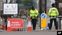 Police officers stand guard close to Victoria Railway Station in Manchester, Britain, May 24, 2017.