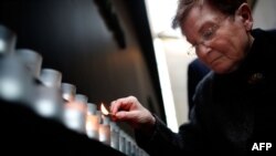 FILE - Holocaust survivor Josiane Traum lights a memorial candle during an International Holocaust Remembrance Day Commemoration at the United States Holocaust Memorial Museum, Jan. 27, 2017, in Washington, D.C. 