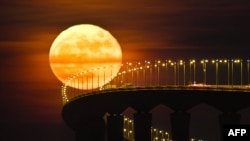 The French "lunatique" means insane. Many ancient cultures blame the moon for insanity. Here, a full moon rising over the Re Island Bridge in Rivedoux, France. 