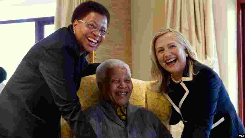 Nelson Mandela, 94, ancien président de l&#39;Afrique du Sud, au centre et son épouse Graça Machel, à gauche, pose pour une photo avec la Secrétaire d&#39;Etat américaine Hillary Clinton, à droite,&nbsp; à Qunu, Afrique du Sud, le 6 août 2012.