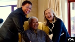 L'ancienne Secrétaire d'Etat américaine Hillary Clinton (R) pose pour une photo avec Nelson Mandela, 94, ancien président de l'Afrique du Sud, et son épouse Graça Machel (L) à son domicile de Qunu, Afrique du Sud, le 6 Août 2012.