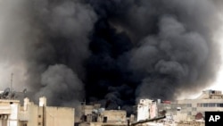 3月19日在阿勒颇，叙利亚政府发动的轰炸使建筑物冒起滚滚黑烟