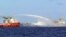 FILE - A Chinese ship (L) shoots a water cannon at a Vietnamese vessel (R) while a Chinese Coast Guard ship (C) sails alongside in the South China Sea, off Vietnam's coast, May 7, 2014. 