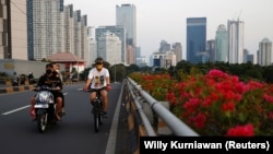 Seorang pria bermasker mengayuh sepeda melalui jalan utama saat pelonggaran PPKM di tengah pandemi COVID-19, di Jakarta, 28 Juli 2021. (Foto: REUTERS/Willy Kurniawan)