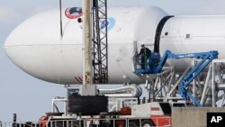 Para petugas memeriksa roket Falcon 9 SpaceX di lokasi peluncuran di Pangkalan Angkatan Udara Cape Canaveral, Florida, 9 Februari 2015. 