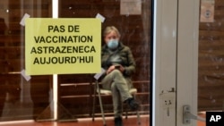 A man waits in a vaccination center where a sign reads 'No AstraZeneca vaccinations today' in Saint-Jean-de-Luz, southwestern France, March 16, 2021.