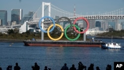 Simbol Olimpiade dipasang kembali setelah diturunkan untuk pemeliharaan menjelang Olimpiade Tokyo 2020 yang ditunda di bagian Odaiba Selasa, 1 Desember 2020, di Tokyo. (Foto: AP/Eugene Hoshiko)