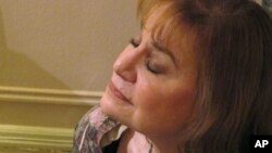 FILE - Kathryn Janus listens to a Death Cafe discussion at a New York City apartment, Oct. 8, 2013. 