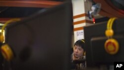 A man uses a computer at an Internet cafe in Beijing, Friday, Dec. 28, 2012. China is increasing already tight controls on Internet use and electronic publishing after embarrassing online reports about official abuses.