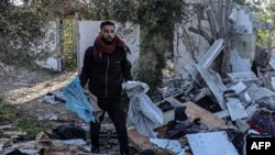 Vayronaga aylangan uyidan omon qolgan narsalarni izlayotgan falastinlik, Rafah shahri, G'azo sektori, 11-mart, 2024. 