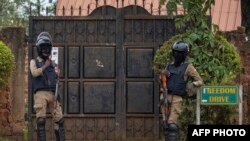 Les forces de sécurité devant le domicile du candidat présidentiel Robert Kyagulanyi, alias Bobi Wine, à Magere, en Ouganda, le 16 janvier 2021, avant l'annonce des résultats des élections ougandaises. (Photo par Sumy SADURNI / AFP)