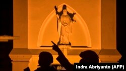 Sejumlah polisi berjaga di Katedral Hati Kudus Yesus di Makassar menjelang perayan Paskah menyusul serangan bom bunuh diri di gereja itu pada 28 Maret, Jumat, 1 April 2021. (Foto: Indra Abriyanto/AFP)