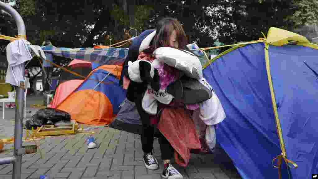 A pro-democracy protester removes her belongings before the workers start to clear away barricades at an occupied area outside government headquarters in Hong Kong, Nov. 18, 2014. 