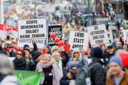 FILE - Demonstrators attend a protest against the government's coronavirus restrictions in Kassel, Germany, March 20, 2021.