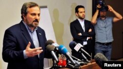 Louay al-Safi, spokesman for the Syrian National Coalition (L), speaks during a news conference in Istanbul May 26, 2013. 